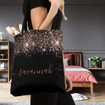 Black rose gold glitter monogram script tote bag<br><div class="desc">A chic black background decorated with rose gold glitter drops. Personalize and add a name. Rose gold colored text. The name is written with a modern hand lettered style script with swashes. To keep the swashes only delete the sample name, leave the spaces or emoji's in front and after the...</div>