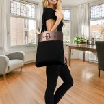 Black rose gold monogram name tote bag<br><div class="desc">Elegant and minimalistic. A chic black background decorated with a rose gold band. Personalize and add your name and monogram letter. Black and brown letters. The name is written with a trendy hand lettered style script with swashes. To keep the swashes only delete the sample name, leave the spaces or...</div>