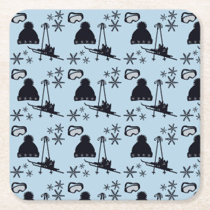Black ski equipment & snowflakes on blue square paper coaster