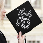 Black | Thanks Mom and Dad Graduation Cap Topper<br><div class="desc">Thank your parents for their support by wearing a custom graduation cap topper in their honor. The stylish graduation cap topper features "Thanks Mom and Dad" in a trendy modern script font against a black background.</div>