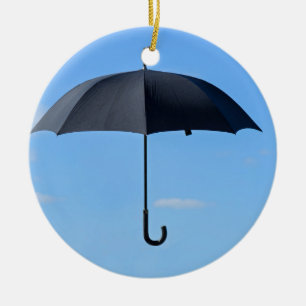 Black umbrella flies in blue sky ceramic ornament