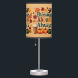 Blessings Abound Always Autumn Design Table Lamp<br><div class="desc">Celebrate the warmth of fall with this cheerful "Blessings Abound Always" design, bursting with cozy seasonal vibes. Surrounded by vivid autumn leaves in shades of crimson, gold, and burnt orange, this playful composition features plaid-patterned typography that radiates rustic charm. The inclusion of pumpkins, a classic football, and a whipped cream-topped...</div>