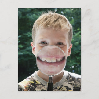 blond boy behind magnifying glass smiling postcard