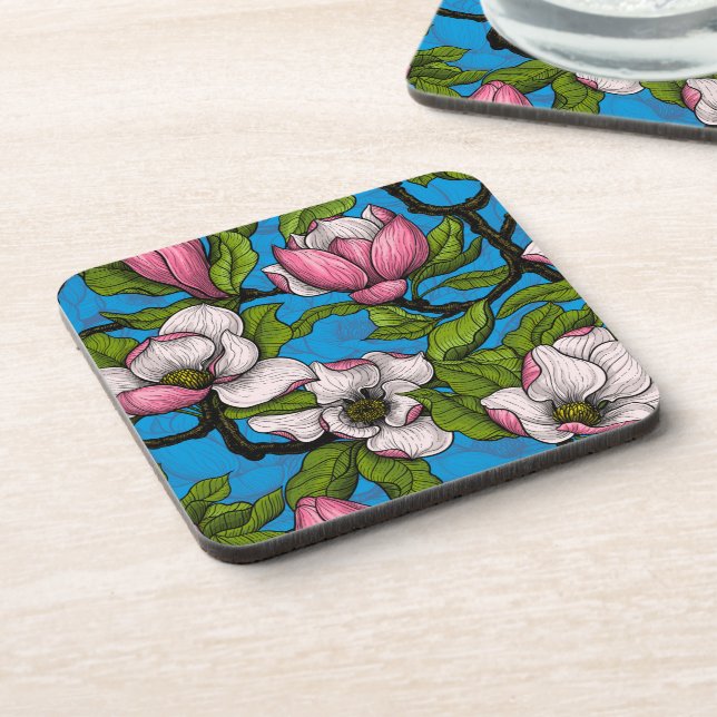 Blooming magnolia on blue beverage coaster (Left Side)
