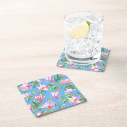 Blooming magnolia on sky blue square paper coaster