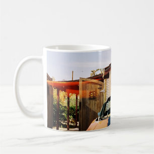 Blue car parked beside brown concrete building in coffee mug