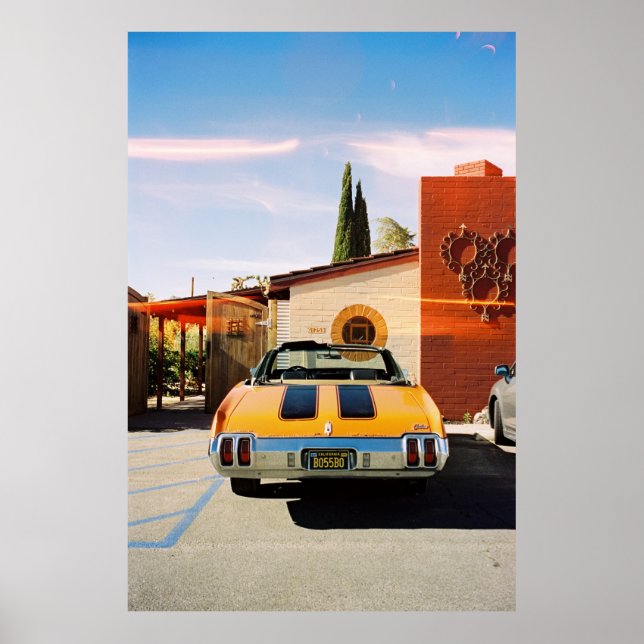 Blue car parked beside brown concrete building in  poster (Front)