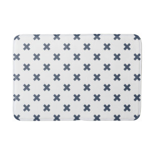 Blue-gray cross stitches on white bath mat