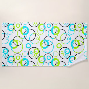 blue green and black rings and circles on white beach towel