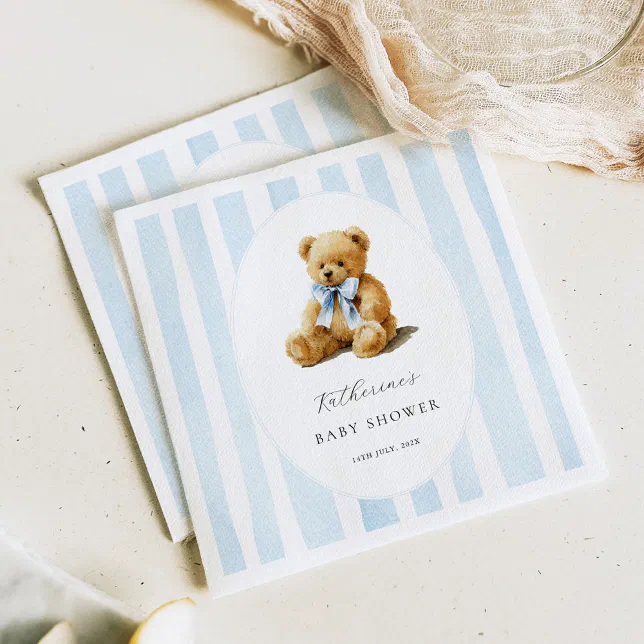 Dusty blue striped napkins are placed on a speckled countertop, with a net fabric beside them.