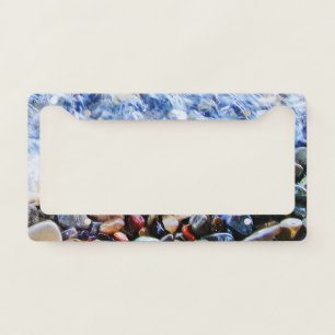 Blue water waving over colorful stones license plate frame
