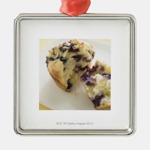 Blueberry muffin split open on a white plate metal ornament