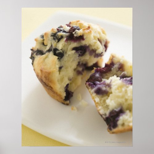 Blueberry muffin split open on a white plate poster