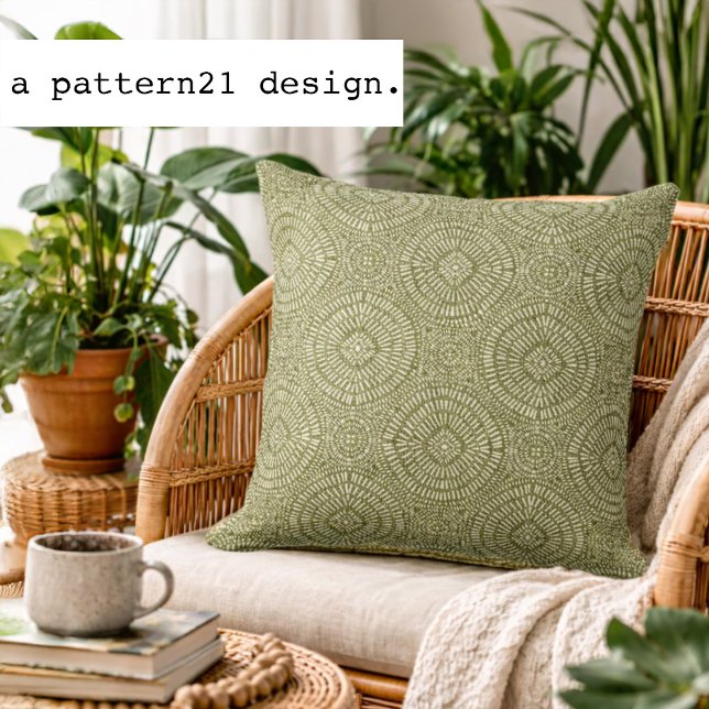 Bohemian green pattern throw pillow (Olive geometric accent pillow styled in a bright plant-filled living space.)