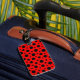 Red and black polka dot luggage tag shown on travel luggage