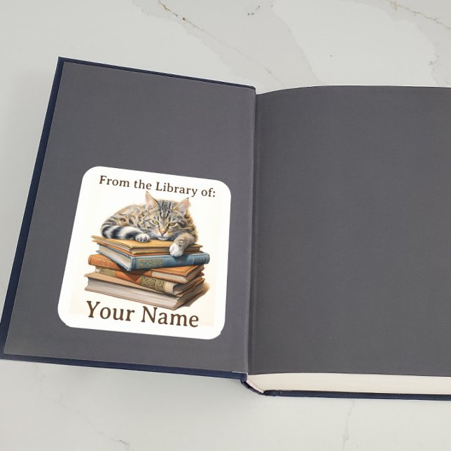 Bookplate with Cat on Books (A bookplate showing a cat lying on some books is displayed inside a book.)