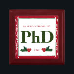 Border Red Green Holly Name Year PhD Graduation Gift Box<br><div class="desc">A square Phd graduation keepsake box with a Christmas feel. The top has a decorative border and a holly berry and leaf accents. It has a red, green, and white color scheme and shows the degree, name, and year. Simply customize this box, add it to your cart, and give it...</div>