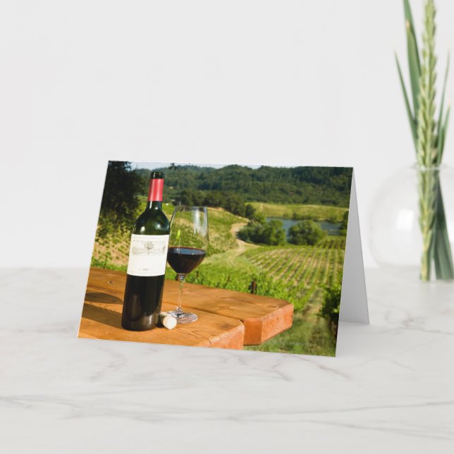 Bottle of red wine and glass on table card (Front)