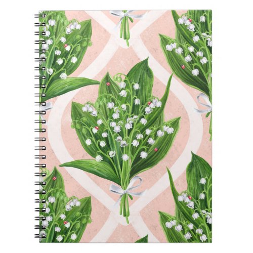 Bouquet of lilly of the valley flowers on pink notebook