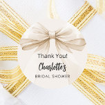 Bow beige cream thank you Bridal Shower Classic Round Sticker<br><div class="desc">A beige,  cream colored background. Decorated with a large bow.  Personalize and add the bride's name. Black handwritten style script.

Text: Thank You!</div>