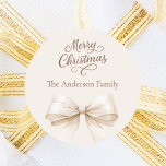 Bow cream beige mocha Christmas Classic Round Sticker<br><div class="desc">A cream,  beige background,   and bow.  Merry Christmas is written with an elegant hand-lettered style script.  Personalize and add your family name.  Mocha,  muted brown colored text.</div>