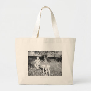Boy feeding antelope by hand large tote bag