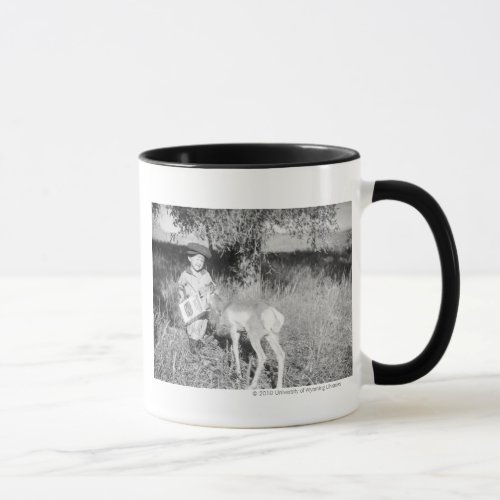 Boy feeding antelope by hand mug