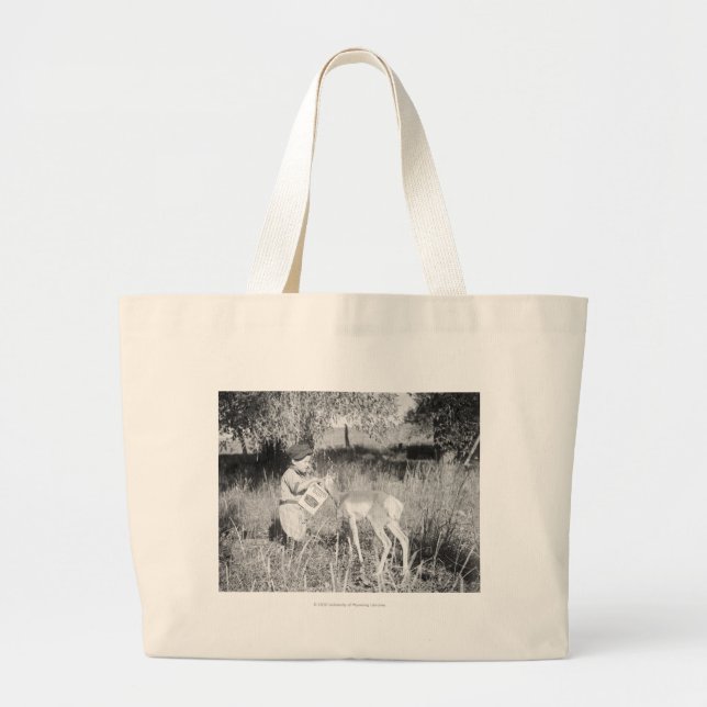 Boy feeding antelope large tote bag (Front)