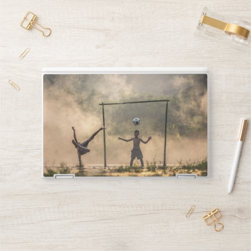 Boy kicking a football in the water HP laptop skin