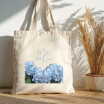 Bridal Party Personalized Blue Floral Tote Bag<br><div class="desc">Blue hydrangea flowers cloth bag. Bridal party tote bag with two lines of text for name and title. Pretty blue script is easy to personalize for a bride, bridesmaid, maid of honor, matron of honor, junior bridesmaid, or flower girl. Pretty light blue hydrangea flowers on stems with green leaves is...</div>