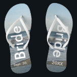 Bride Ocean Waves Beach Sand Flip Flops<br><div class="desc">Pretty Blue Sky with Light Fluffy White Clouds, Blue Sea, Crashing Ocean Waves and Beach Sand. Unisex Flip Flops with Bride and Date of Marriage written in a white text. PERSONALIZE with your Wedding DATE (or delete text). The wedding date is written in the sand. Choose wide or slim straps...</div>