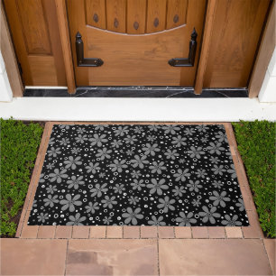 Bright orange flowers on a black background with w doormat