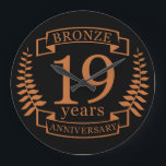 Bronze traditional wedding anniversary 19 years large clock<br><div class="desc">A design to celebrate 19 years of marriage. This design has a bronze colored laurel design on a black background. Bronze is the traditional gift for this occasion. The text reads bronze 19 years anniversary. A romantic design to celebrate your 19th year of marriage. If you would like any help...</div>