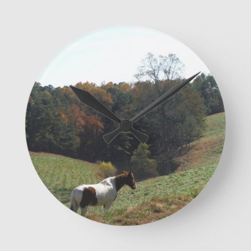 Brown and white horse at autumn pond round clock