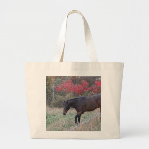 Brown horse in the red autumn trees large tote bag