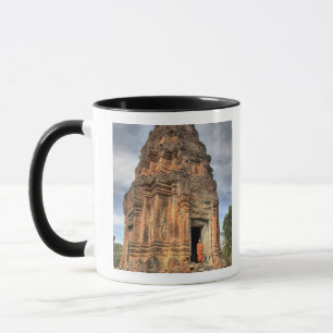 Buddhist monk standing in doorway of temple mug