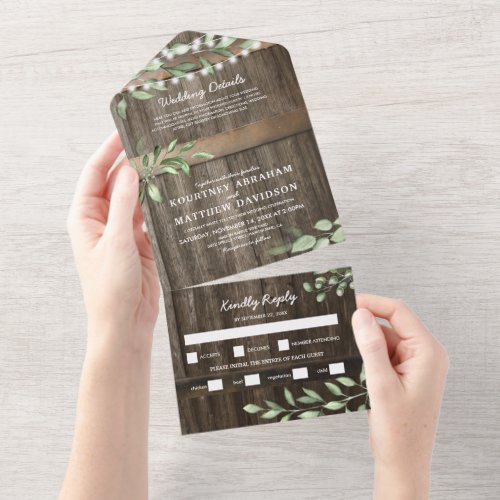 Budget Rustic Greenery Wedding All In One Invitation - A 3 in 1 rustic country chic wedding trifold invitation featuring a rustic wood barrel background, twinkle string lights, botanical greenery watercolor foliage, your monogram, wedding details, wedding invite, and a meal rsvp postcard for your guests to tear off and send back.