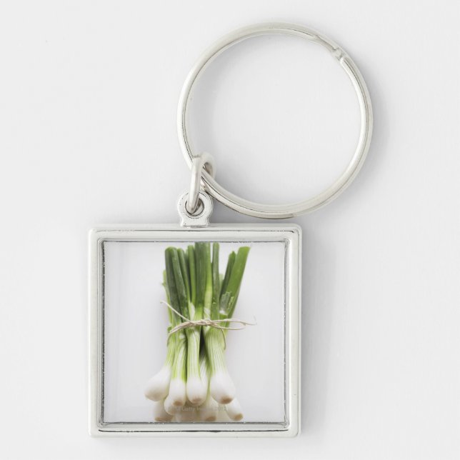 Bunch of spring onions on white chopping board keychain (Front)