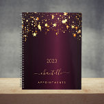 Burgundy gold stars name elegant 2023 planner<br><div class="desc">A dark burgundy faux metallic looking background, decorated with faux gold dripping stars. Personalize and add a name and a title. The name is written with a golden modern hand lettered style script with swashes. Perfect for school, work or organizing your personal/family life. To keep the swashes only delete the...</div>