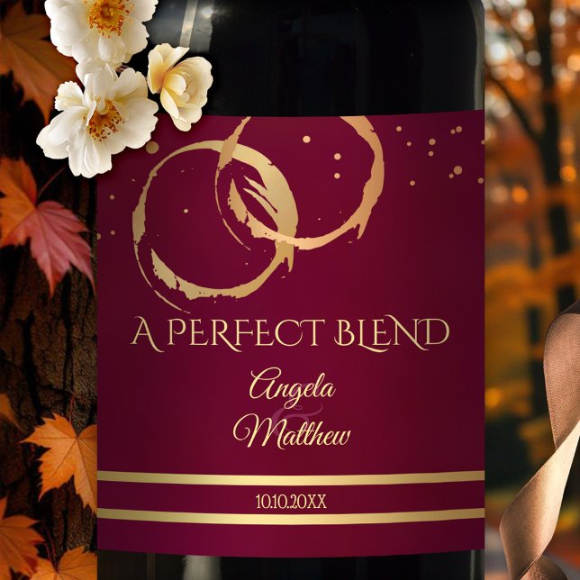Burgundy Gold Wine Stains Wedding Wine Label (Wedding wine label featuring gold and rose gold intersecting ring wine stains on stylish burgundy)