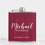 Burgundy Red Modern Script Personalized Groomsmen Flask<br><div class="desc">Add a personal touch to your wedding with personalized groomsmen flask. This flask features personalized groomsmen's name in white modern script font style and monogram in light red modern script font style as background with title and wedding date in white modern sans serif font style on burgundy red background. Also...</div>