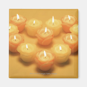 Burning candles arranged in a heart shape magnet