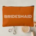 Burnt Orange Modern Typography Bridesmaid Accessory Pouch<br><div class="desc">Solid brunt orange color,  small style,  zippered cosmetic bag for your wedding bridesmaid that features the word,  BRIDESMAID in large,  modern typography on one side of bag. Perfect as a travel accessory pouch to hold makeup,  perfume,  and jewelry. You may personalize by adding bridesmaid name if desired to pouch.</div>