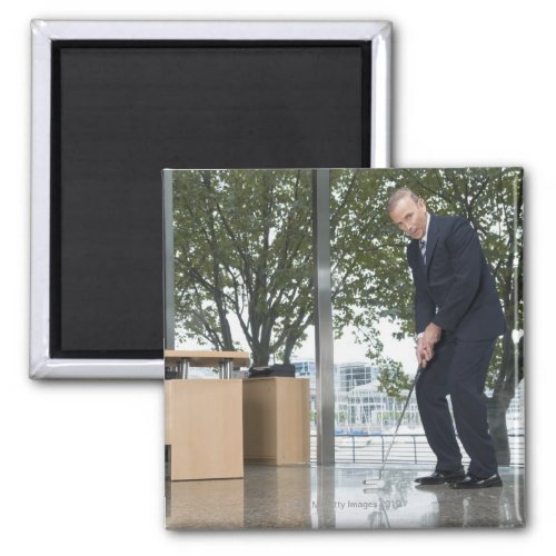 Businessman playing golf in an office magnet