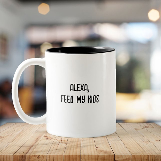 Busy Parent Funny Tired Mom Mothers Day Two-Tone Coffee Mug (White mug on a wooden table with black interior and text reading "Alexa, feed my kids." )