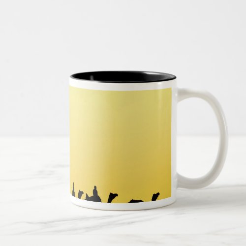 Camels and camel driver silhouetted at sunset 3 Two_Tone coffee mug
