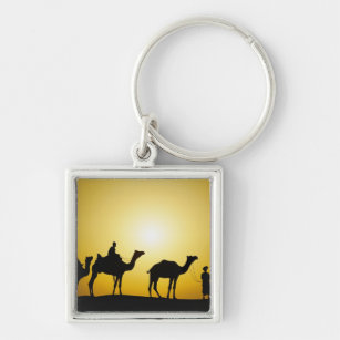 Camels and camel driver silhouetted at sunset, keychain