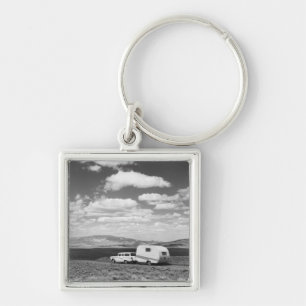 Car pulling trailer on road keychain
