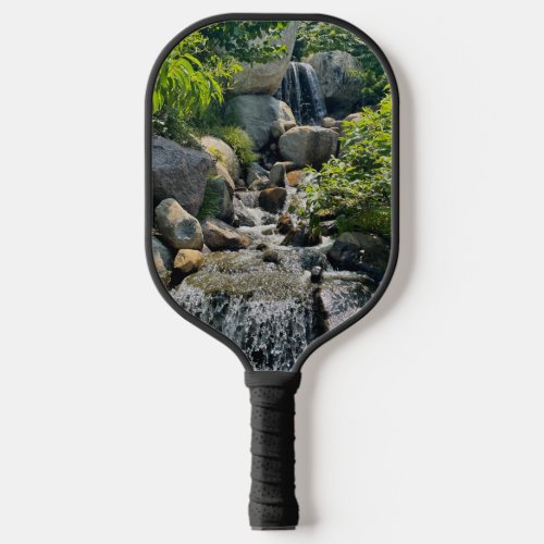 Cascading forest waterfall  forest greenery   pickleball paddle