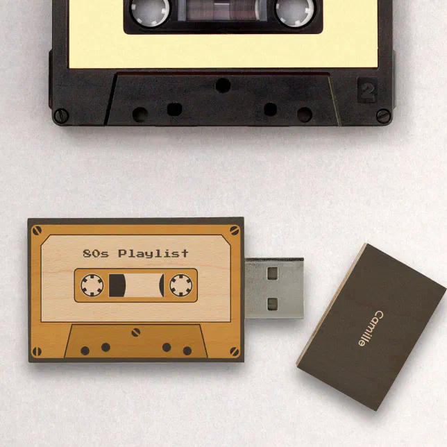 A USB flashdrive with a cassette player deisgn sits next to a real cassette tape.